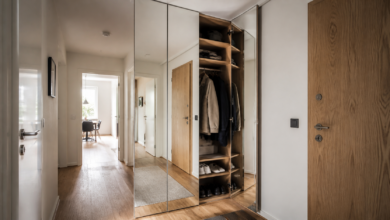 Geöffnete Garderobe hinter bodentiefen Spiegelpaneelen im Flur [Bildinhalt mit KI erstellt]