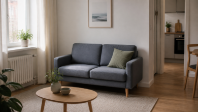 Kompaktes graublaues Zweiersofa in einem kleinen Wohnzimmer [Bildinhalt mit KI erstellt]